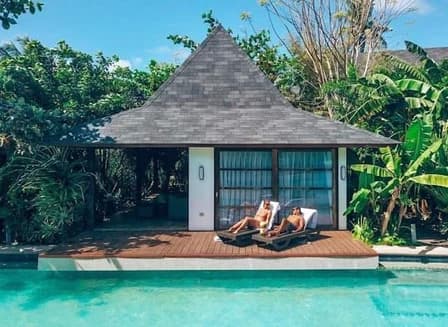Floating villa with a private deck opening directly onto the lagoon-style pool