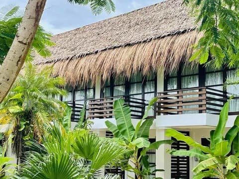 Terrace Deluxe rooms with thatched roof balconies among tropical plants
